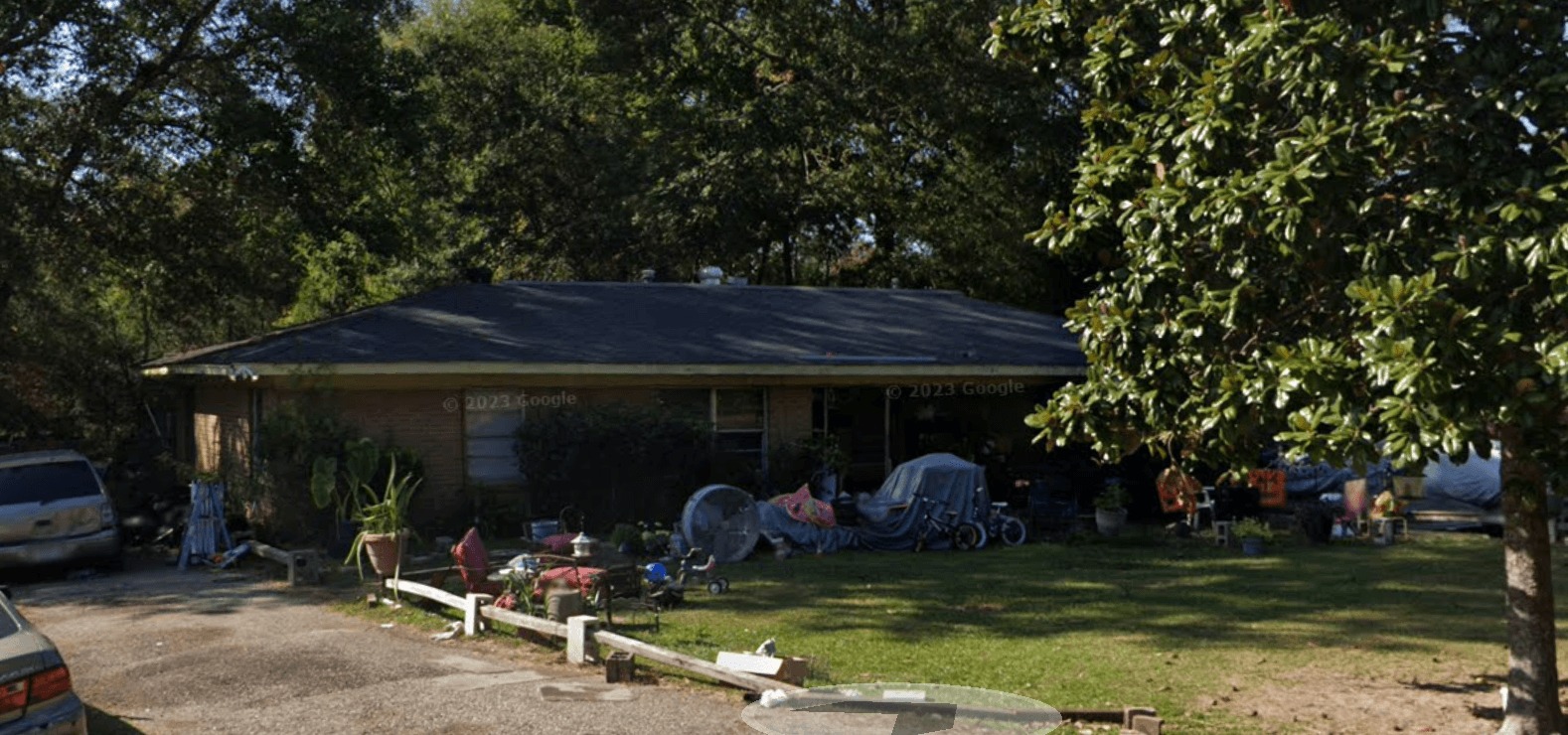 a house with a yard and parked cars in front of it